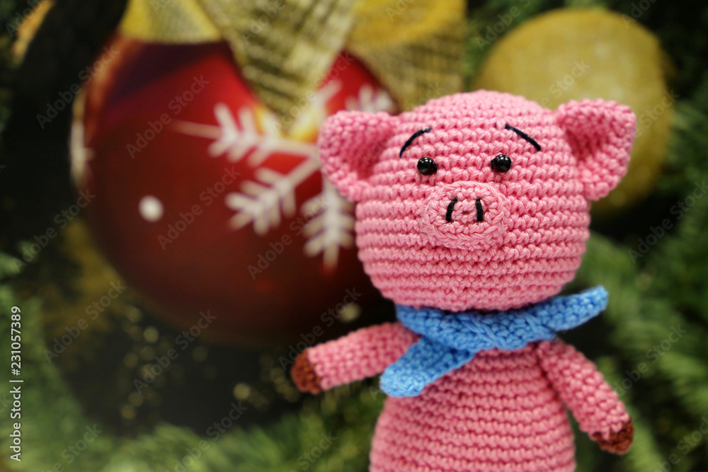 Knitted toy pig on christmas decorations background. Festive card, Chinese New Year of Pig, Zodiac symbol 2019