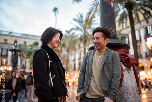 Asian happy tourist couple talking in a square