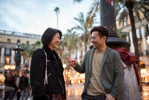 Asian happy tourist couple talking in a square