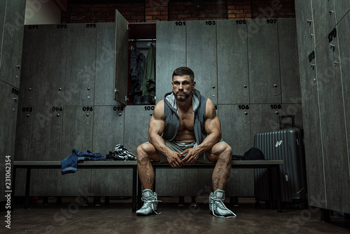 Bodybuilder sitting in locker room