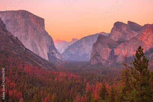 Tunnel View overlook at golden hour in Yosemite National Park. El Capitan and Half Dome at red sunset. Summer american holidays. California, United States.