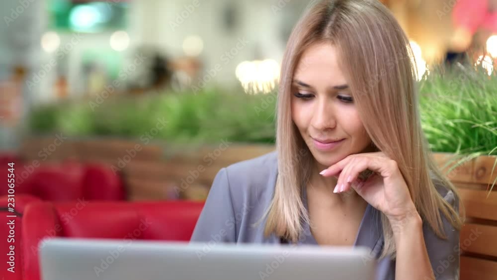Portrait of happy beautiful European woman enthusiastically looking at screen using laptop Portrait of happy beautiful European woman enthusiastically looking at screen using laptop