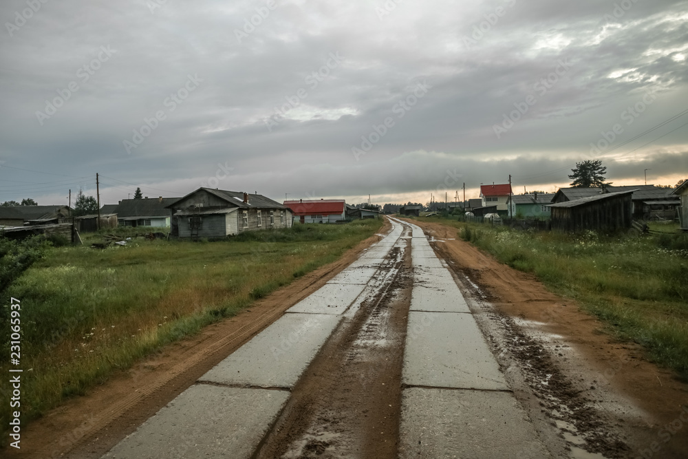 The nature of the Russian North. Arkhangelsk region. Clouds over the road in the village. Rain