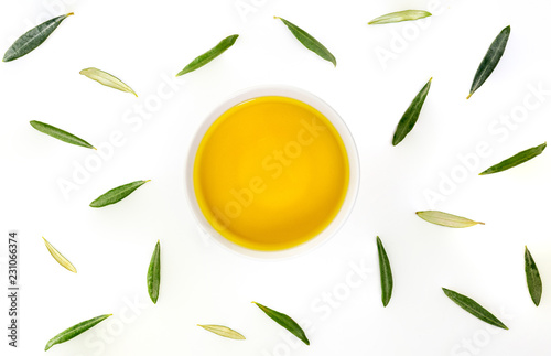 Bowl of extra virgin olive oil with olive leaves. Zenital plane on white background. photo