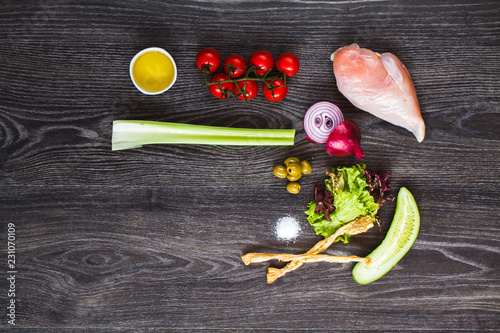 ingredients for cooking, chicken breast and vegetables on a wooden table