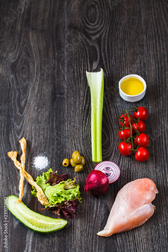 ingredients for cooking, chicken breast and vegetables on a wooden table