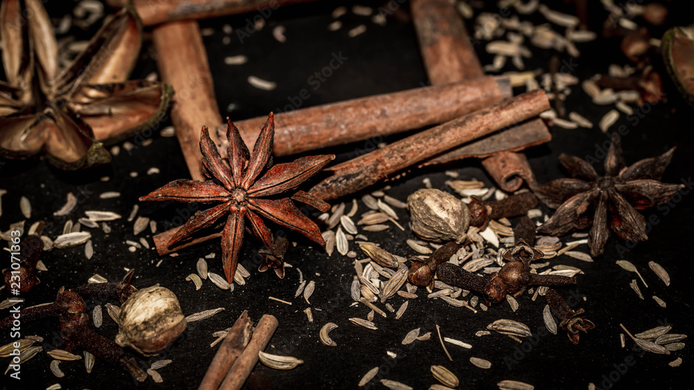 various aromatic spices and herbs on black background. star anise, cloves, cardamom, cinnamon stick various aromatic spices and herbs on black background. star anise, cloves, cardamom, cinnamon stick