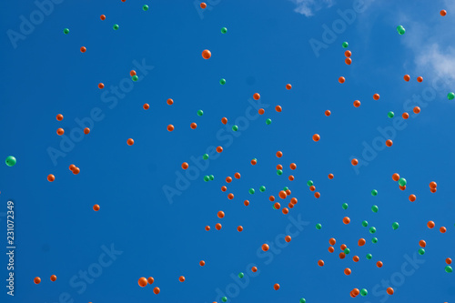 Flying colorful balloons in the city festival on blue sky background. 