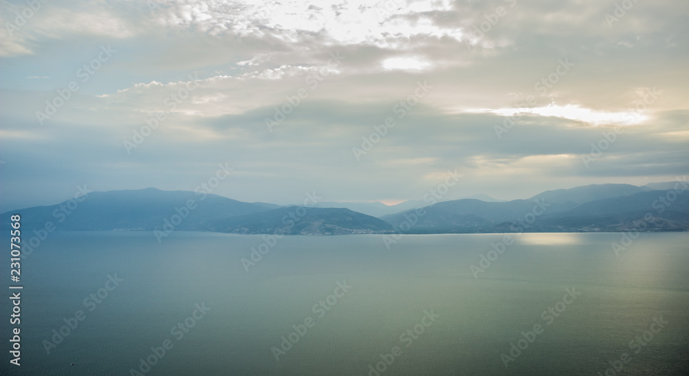 morning mountains silhouettes and calm sea bay horizon landscape panorama in quiet sun rise morning time 