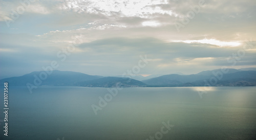 morning mountains silhouettes and calm sea bay horizon landscape panorama in quiet sun rise morning time 