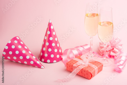 Champagne, gift, bow. Invitation, birthday, party on the occasion of girlhood, the concept of a baby shower, a holiday on a pink background. Banner for inscriptions, announcements for birthday