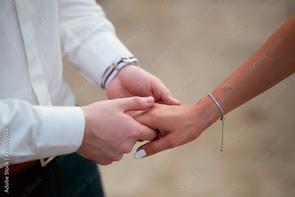 Groom holds bride's hand tender Groom holds bride's hand tender