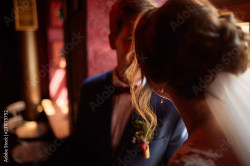 Bride and groom talk to each other sitting in a dark room