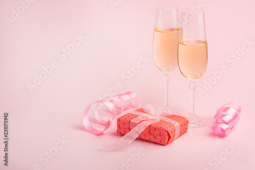 Champagne, gift, bow. Invitation, birthday, party on the occasion of girlhood, the concept of a baby shower, a holiday on a pink background. Banner for inscriptions, announcements for birthday