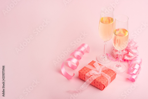 Champagne, gift, bow. Invitation, birthday, party on the occasion of girlhood, the concept of a baby shower, a holiday on a pink background. Banner for inscriptions, announcements for birthday