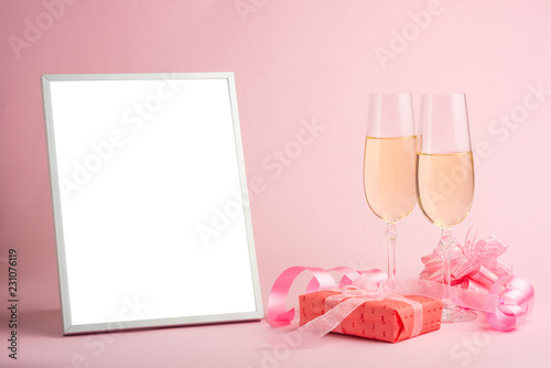 Champagne, gift, bow. Invitation, birthday, party on the occasion of girlhood, the concept of a baby shower, a holiday on a pink background. Banner for inscriptions, announcements for birthday