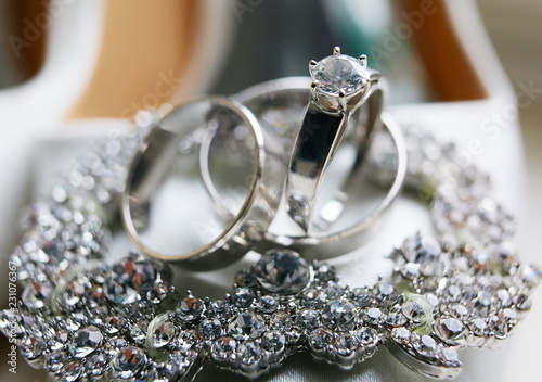 Classy silver wedding rings made of white gold lie on the crystal bracelet