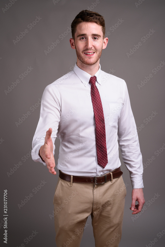 Portrait of young handsome businessman against gray background Portrait of young handsome businessman against gray background