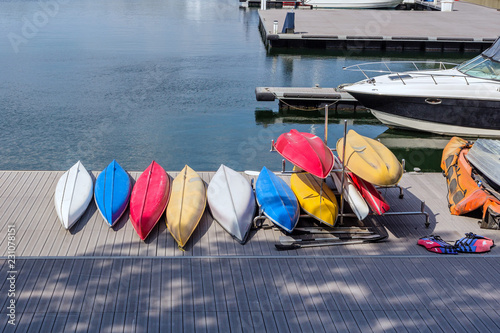 Colorful fiberglass kayaks tethered to a dock as seen from above