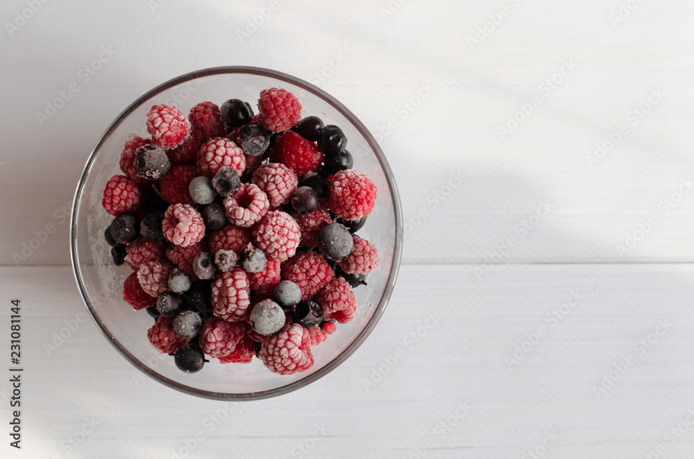 the frozen berries raspberry and currant in a glass plate on a white background the frozen berries raspberry and currant in a glass plate on a white background