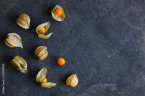 .Arrangement of physalis fruit, Cape Gooseberries, on natural slate background with copy space to right