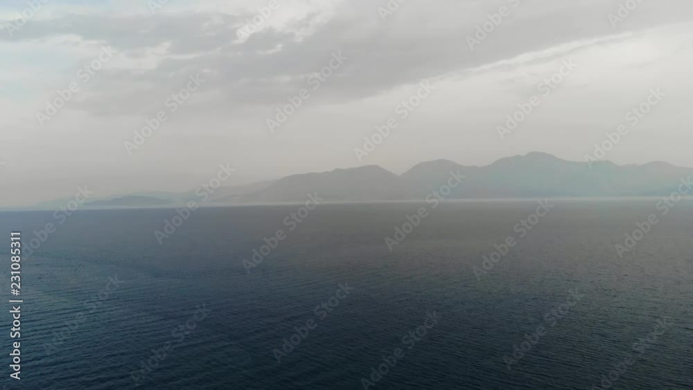 The drone is flying towards the island. Flying camera over the sea towards the island. Sea view of the Islands. Islands in fog. Aerial view. 4K The drone is flying towards the island. Flying camera over the sea towards the island. Sea view of the Islands. Islands in fog. Aerial view. 4K