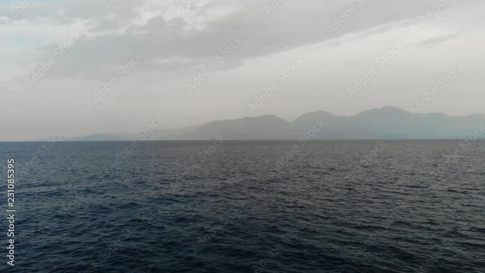 The drone is flying towards the island. Flying camera over the sea towards the island. Sea view of the Islands. Islands in fog. Aerial view. 4K The drone is flying towards the island. Flying camera over the sea towards the island. Sea view of the Islands. Islands in fog. Aerial view. 4K