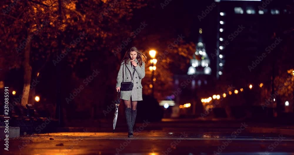 The girl walks with an umbrella in the night city The girl walks with an umbrella in the night city