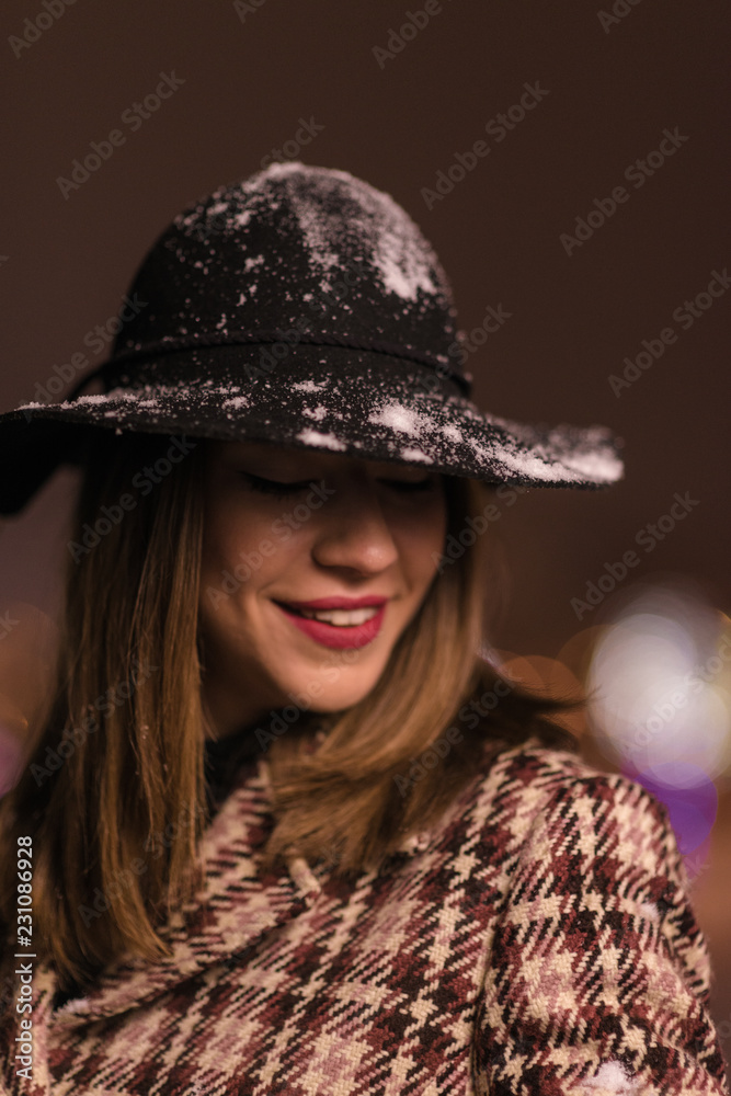 Young girl standing in front on christmas tree lights. girl on christmass alone in the park