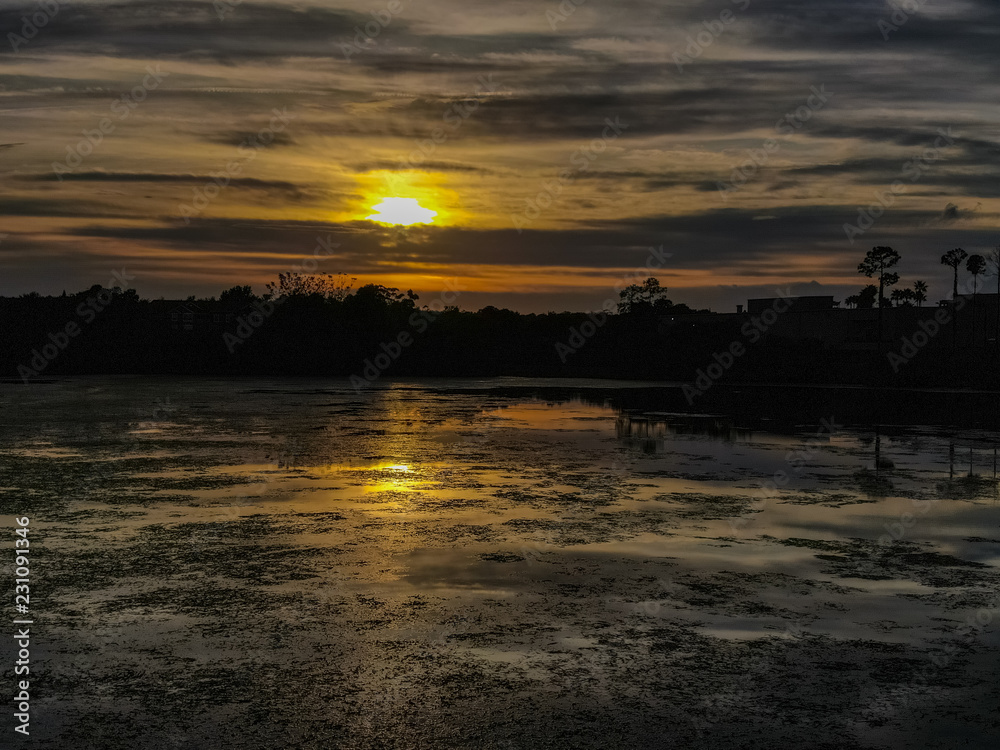 Naklejka premium lake on sunset sun coming down