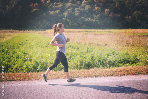 woman jogging along a country road © .shock