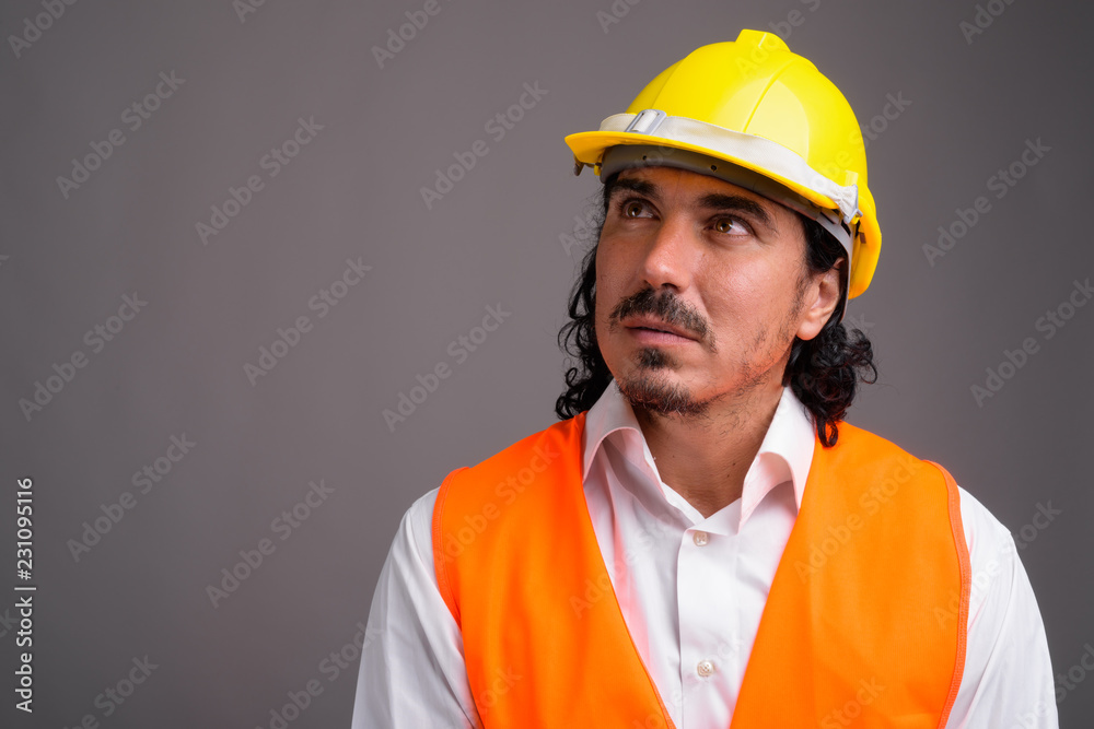 Handsome man construction worker with mustache against gray back