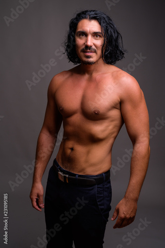 Muscular handsome man with mustache shirtless against gray backg