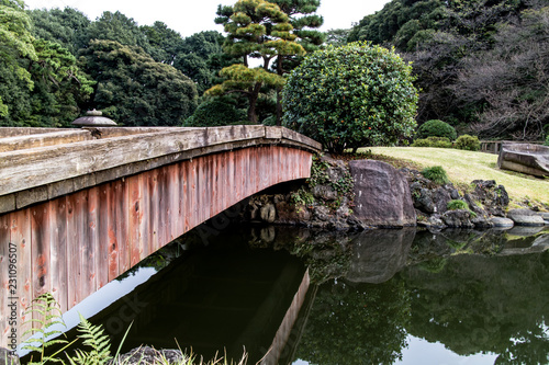 An old wooden bridge crossing a lake in a Japanese zen garden