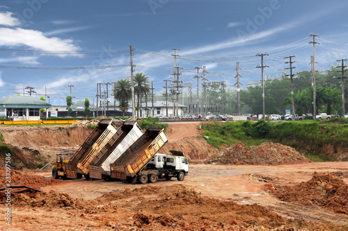 Land reclamation for solar power plants and biomass power plants with tractor and dump trucks.