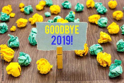 Text sign showing Goodbye 2019. Conceptual photo New Year Eve Milestone Last Month Celebration Transition Clothespin holding gray note paper crumpled papers several tries mistakes photo