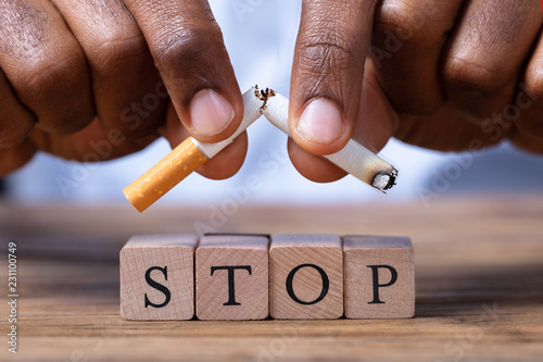 Obraz na plátně Man Breaking Cigarette Over Wooden Stop Blocks
