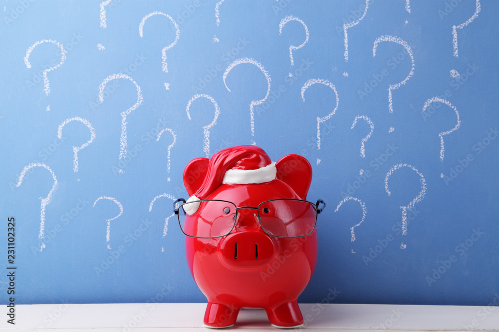 Red piggy bank with glasses in front of a blue chalkboard full of ...