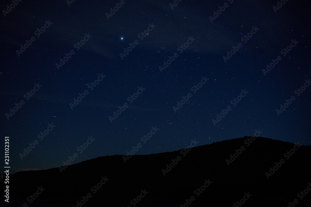 Mountains in Pennsylvania silhouetted against a dark, starry sky.