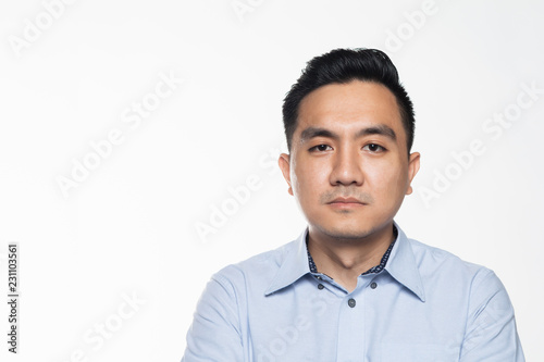 Asian man in work attire with serious face