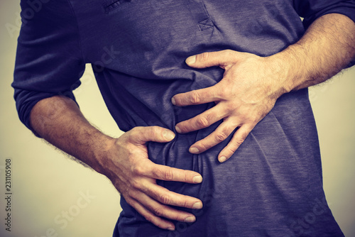 Man feeling stomach ache pain © Voyagerix