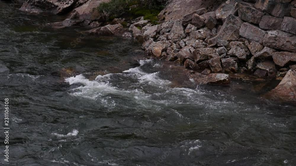 Mountain river flowing in slow motion. Norwegian green nature in summer. Saltfjellet - Svartisen National Park in Norway Mountain river flowing in slow motion. Norwegian green nature in summer. Saltfjellet - Svartisen National Park in Norway