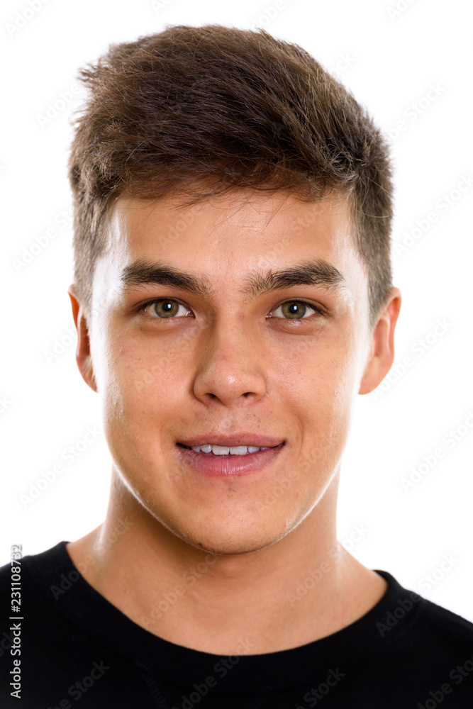 Face of young handsome man smiling and looking at camera Face of young handsome man smiling and looking at camera