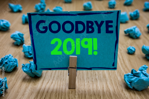 Handwriting text writing Goodbye 2019. Concept meaning New Year Eve Milestone Last Month Celebration Transition Clothespin holding blue paper note crumpled papers several tries mistakes photo