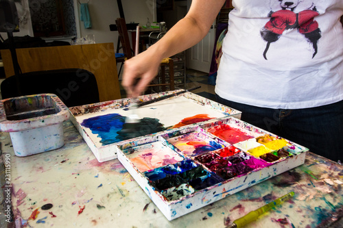 woman mixing paint in a paint tray