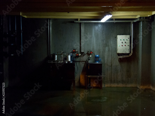 Industrial basement with wet floor. Dark gloomy ambient terror movie concept 