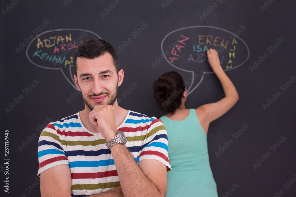 pregnant couple writing on a black chalkboard