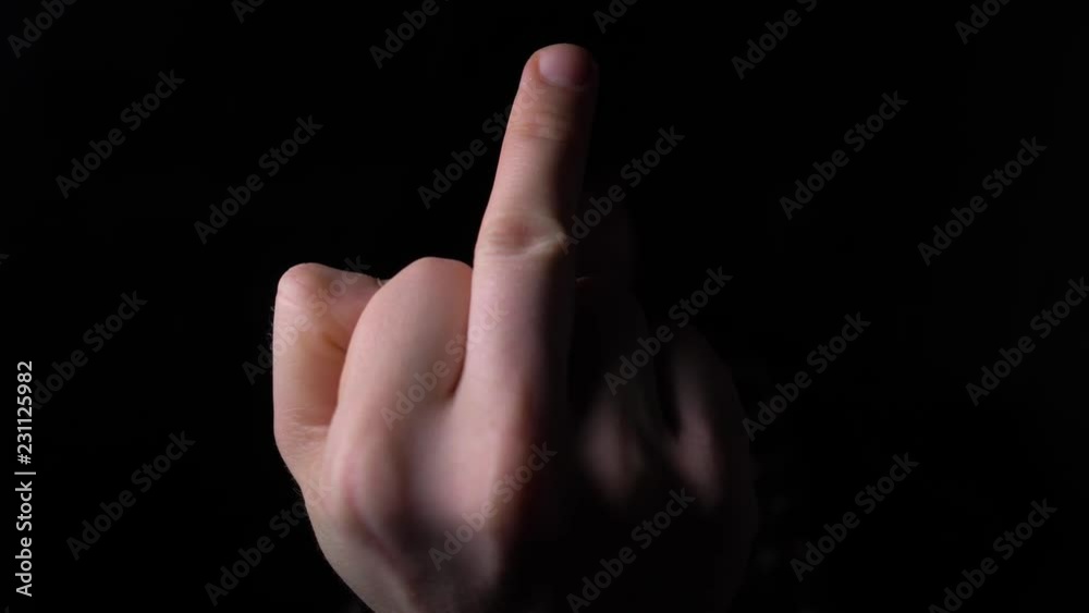 male Hand Showing Middle Finger out of the Darkness. 4K slow motion