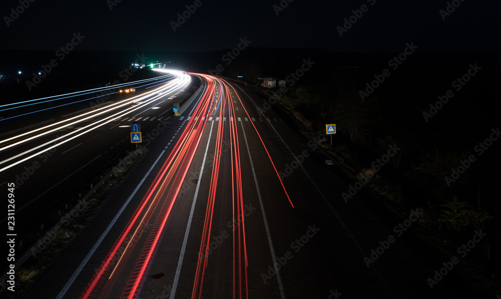 cars red and white trails of lights at night on road. long exposure photo. cars lights lines