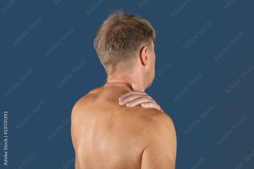 Man holding his sore shoulder trying to relieve pain. Health problems Man holding his sore shoulder trying to relieve pain. Health problems